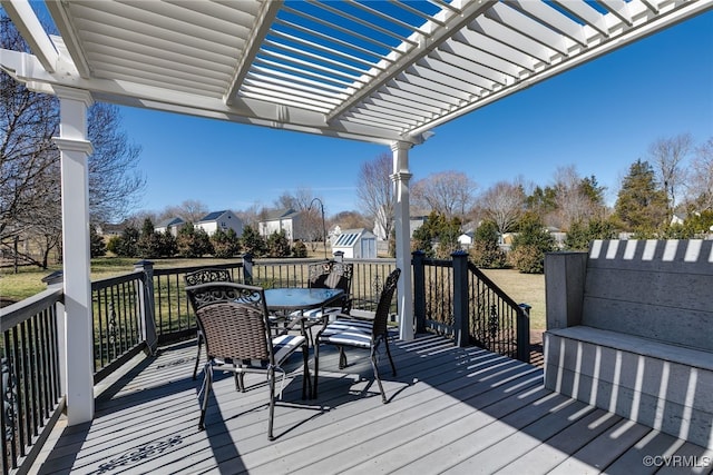 wooden terrace featuring a shed, outdoor dining area, an outdoor structure, and a pergola