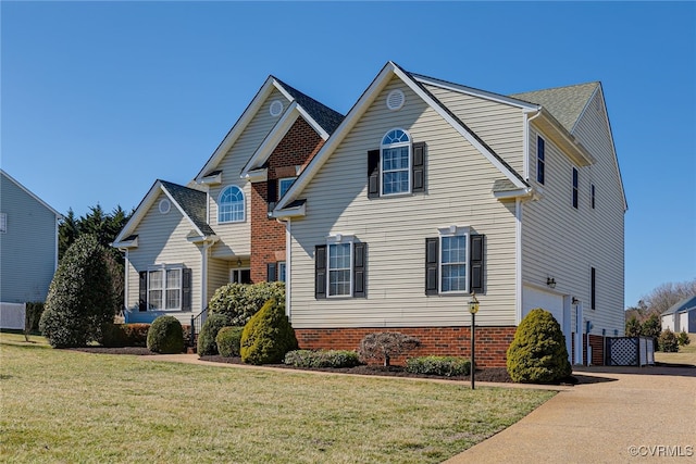 traditional-style home with a garage, concrete driveway, and a front lawn