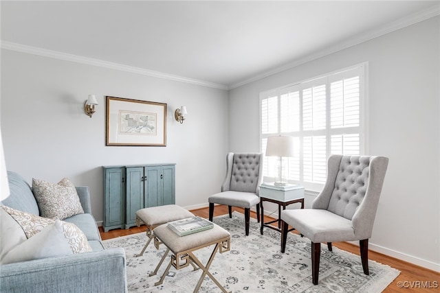 living area featuring ornamental molding, light wood-type flooring, and baseboards