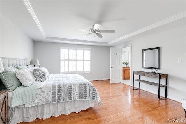 bedroom featuring light wood-style floors, baseboards, ornamental molding, and a raised ceiling