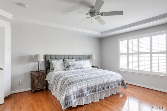 bedroom with a ceiling fan, wood-type flooring, baseboards, and crown molding