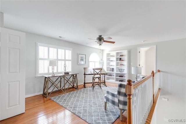 sitting room featuring hardwood / wood-style flooring, baseboards, visible vents, and ceiling fan