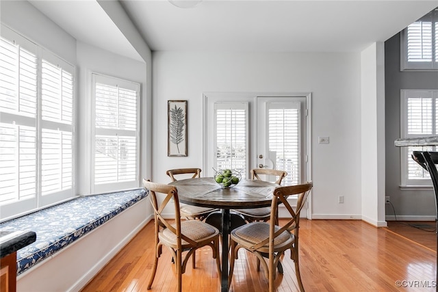 dining area featuring light wood-type flooring and baseboards