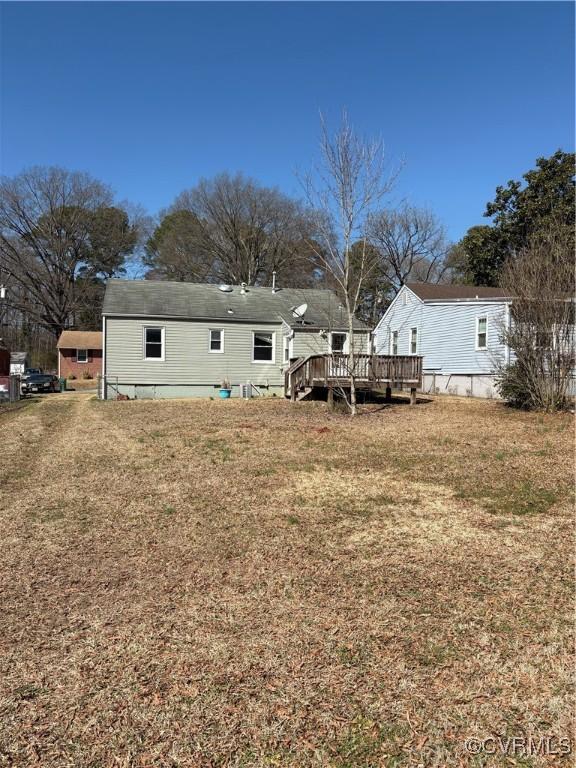 back of property featuring a deck and a yard