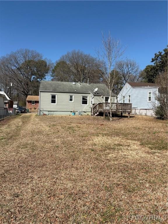 rear view of house with a yard and a wooden deck