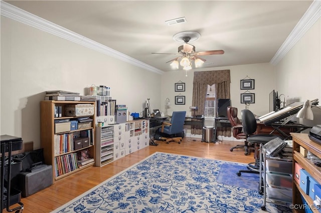 home office with ornamental molding, wood finished floors, visible vents, and a ceiling fan