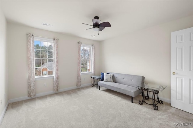 living area featuring a ceiling fan, baseboards, visible vents, and carpet flooring