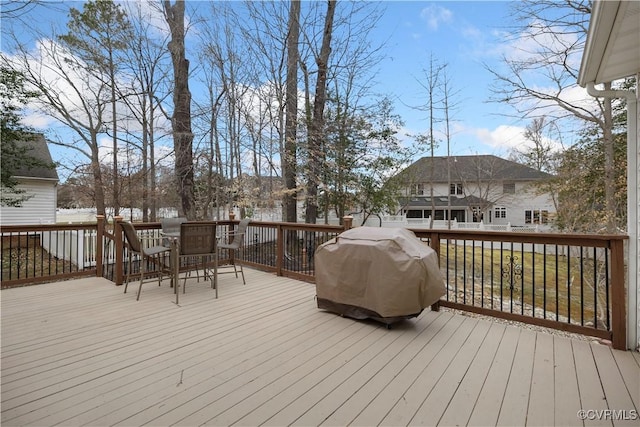 wooden deck featuring outdoor dining space and a grill