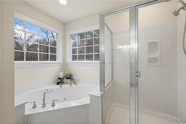 bathroom featuring a stall shower and a jetted tub