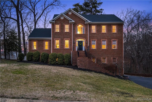 view of front of home featuring a front yard and brick siding