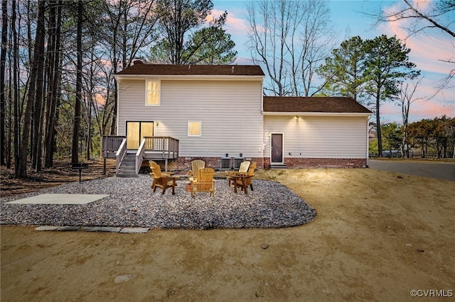 rear view of house featuring a wooden deck and an outdoor fire pit