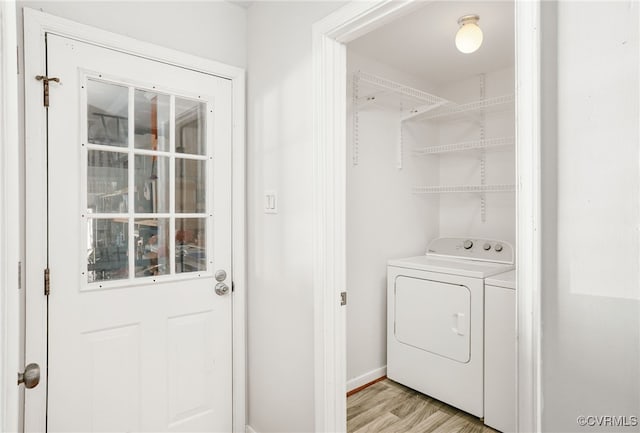 laundry area featuring laundry area, light wood-style flooring, and separate washer and dryer