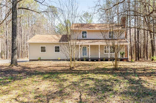 view of front of house featuring covered porch and a chimney