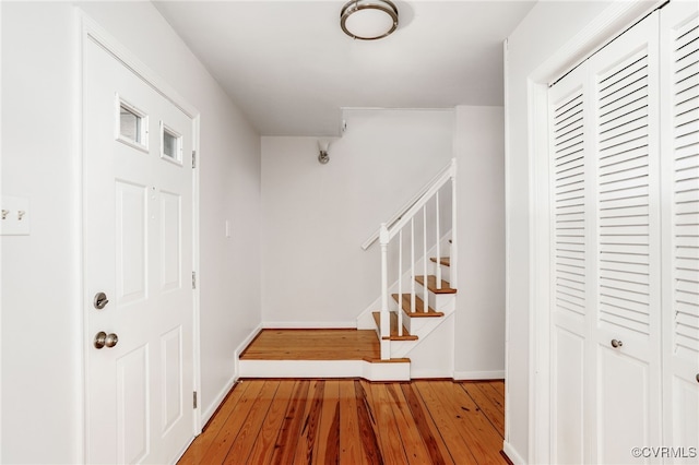 entrance foyer with stairway, baseboards, and hardwood / wood-style flooring