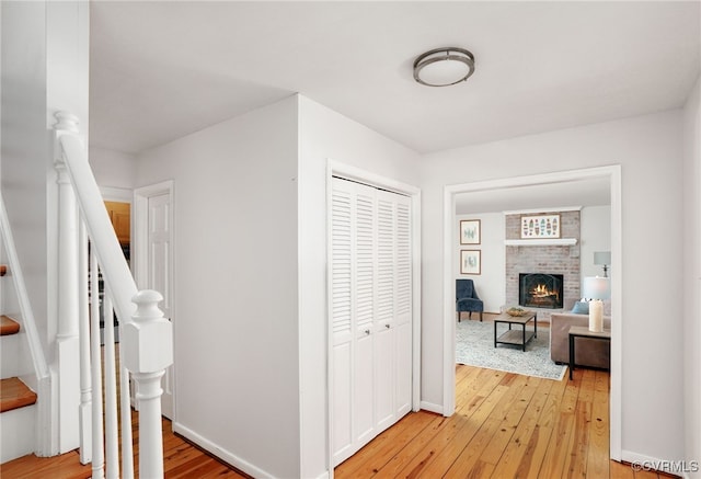 corridor featuring stairway, baseboards, and light wood-style flooring