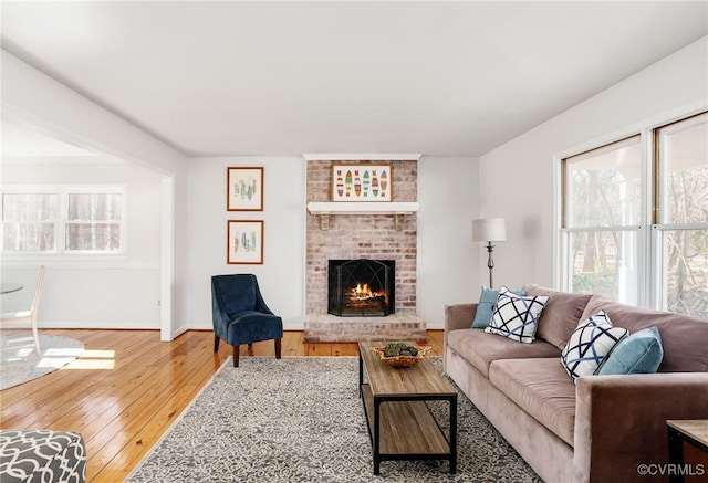 living area featuring hardwood / wood-style floors, a fireplace, and baseboards