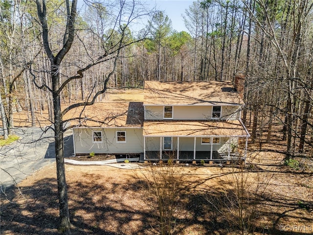 rear view of house featuring a chimney