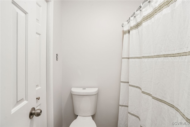 bathroom featuring a shower with shower curtain and toilet