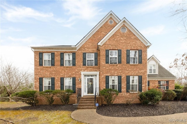 colonial house featuring brick siding