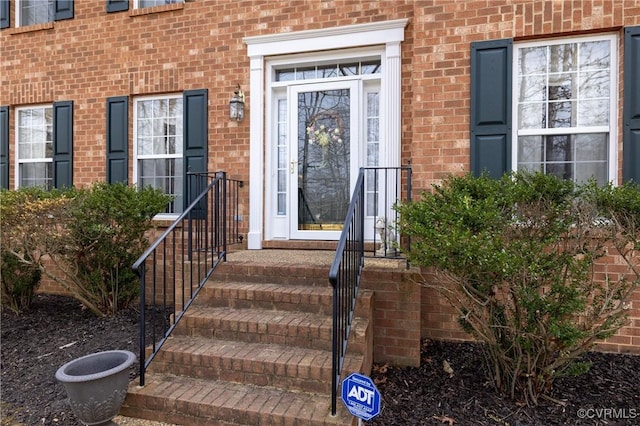 doorway to property featuring brick siding