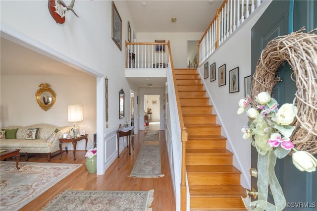 interior space with a high ceiling, baseboards, and wood finished floors