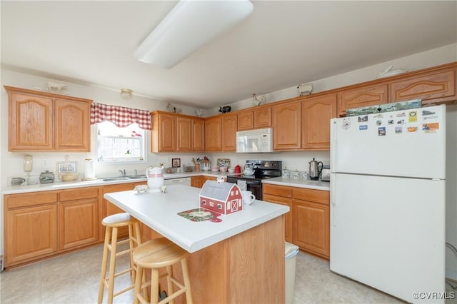 kitchen with white appliances, a kitchen island, a breakfast bar, light countertops, and a sink