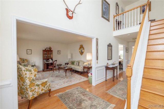 living room with stairs, a high ceiling, and wood finished floors