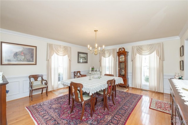 dining space featuring plenty of natural light, a wainscoted wall, and crown molding