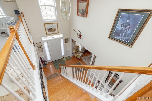 foyer entrance featuring stairs, a high ceiling, and wood finished floors