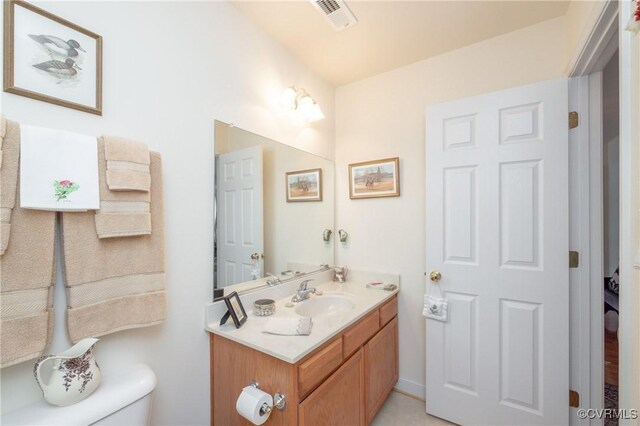 half bath featuring toilet, visible vents, and vanity