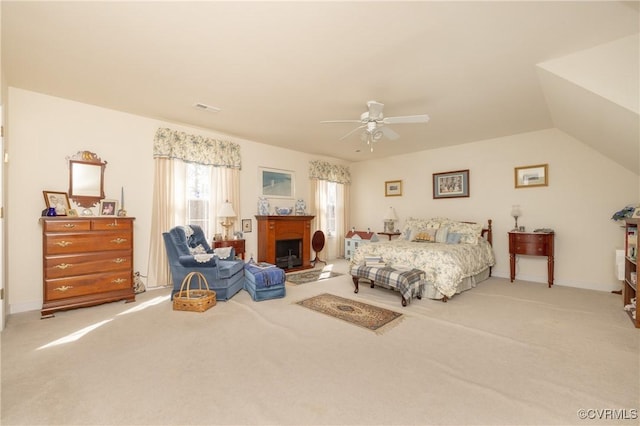 carpeted bedroom with lofted ceiling, a fireplace, visible vents, baseboards, and a ceiling fan