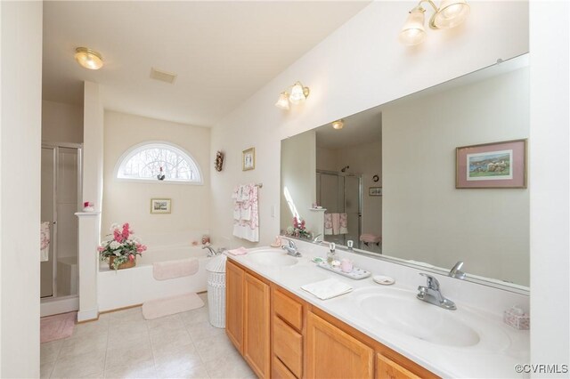 bathroom featuring double vanity, a stall shower, visible vents, and a sink