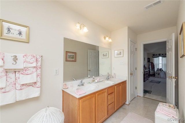 full bath with double vanity, visible vents, a sink, and tile patterned floors