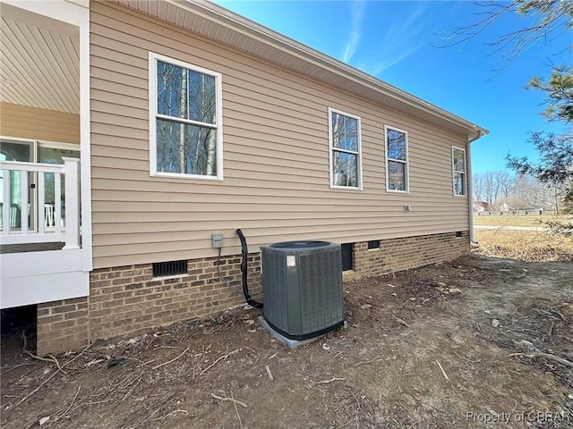 view of property exterior with crawl space and central air condition unit