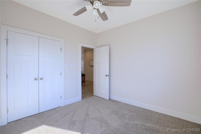 unfurnished bedroom with carpet, a closet, ceiling fan, and baseboards