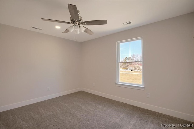 carpeted empty room featuring a ceiling fan, visible vents, and baseboards