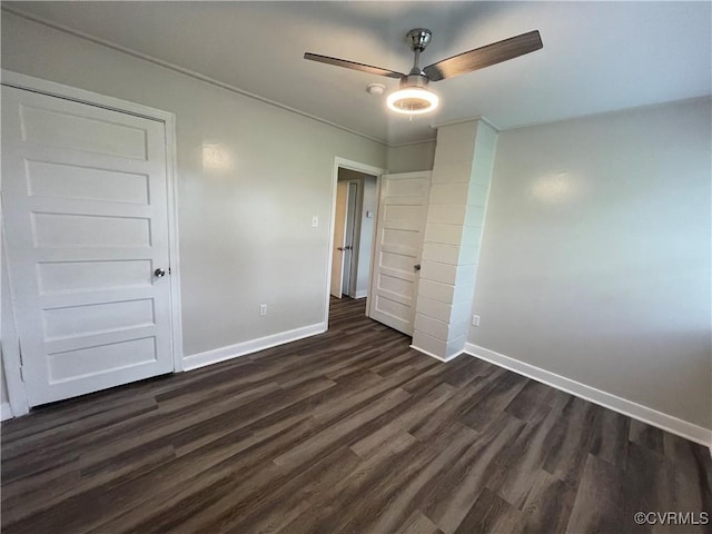 unfurnished bedroom featuring dark wood finished floors, a ceiling fan, and baseboards