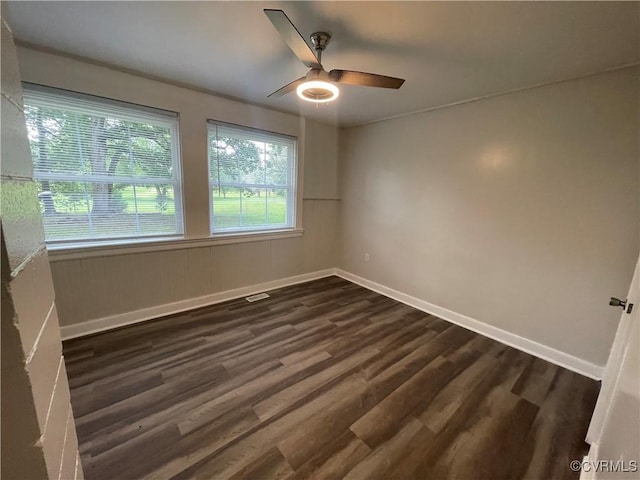 unfurnished room featuring dark wood-style floors, ceiling fan, and baseboards