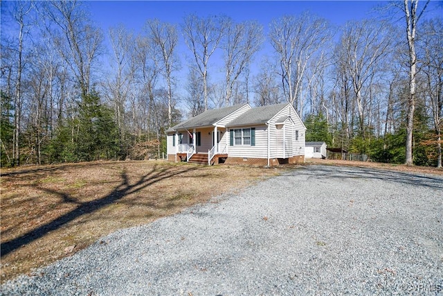 view of front of property featuring a porch, crawl space, and gravel driveway