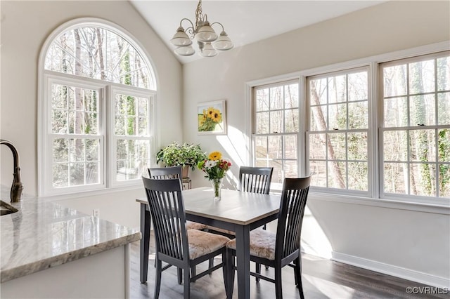 dining space with vaulted ceiling, dark wood-style flooring, a healthy amount of sunlight, and a notable chandelier