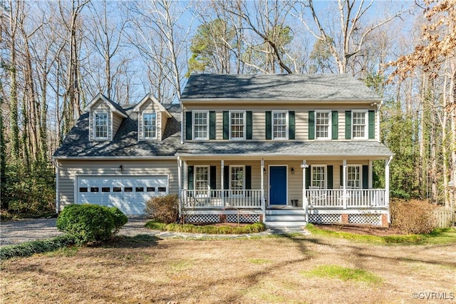 colonial-style house featuring an attached garage, dirt driveway, a porch, and roof with shingles