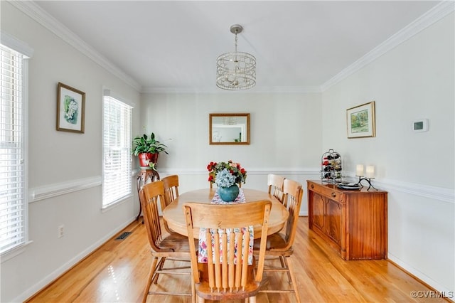 dining area featuring light wood-type flooring, visible vents, and crown molding