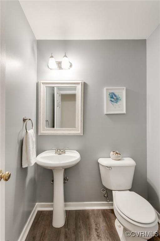 bathroom featuring wood finished floors, toilet, and baseboards