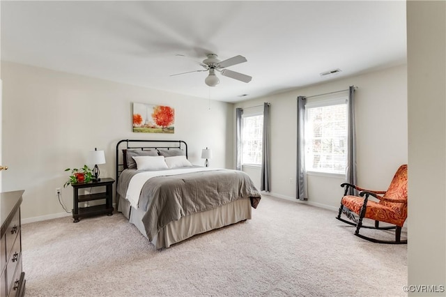 bedroom featuring a ceiling fan, light colored carpet, visible vents, and baseboards