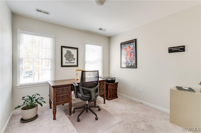 home office with plenty of natural light, visible vents, and carpet flooring