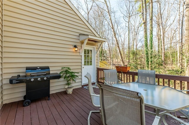 wooden terrace featuring outdoor dining space and area for grilling