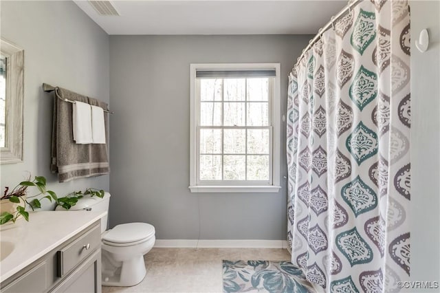 bathroom featuring toilet, tile patterned floors, vanity, and a healthy amount of sunlight