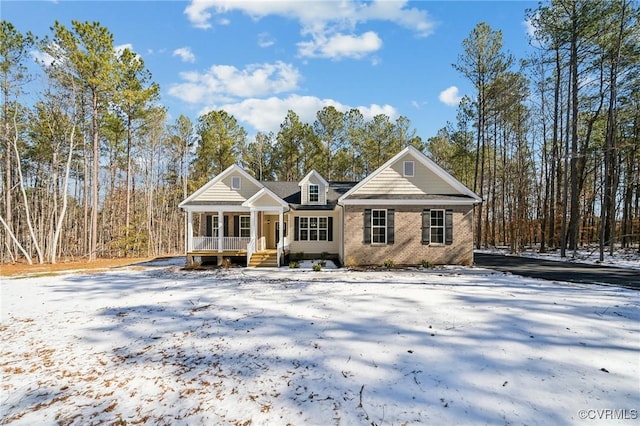 view of front of house with a porch and brick siding