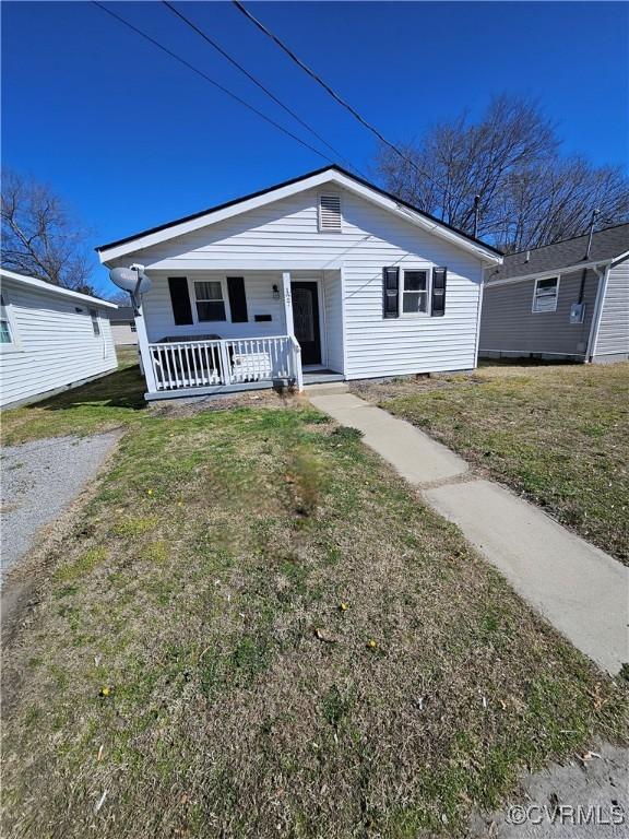 bungalow-style house with covered porch and a front lawn