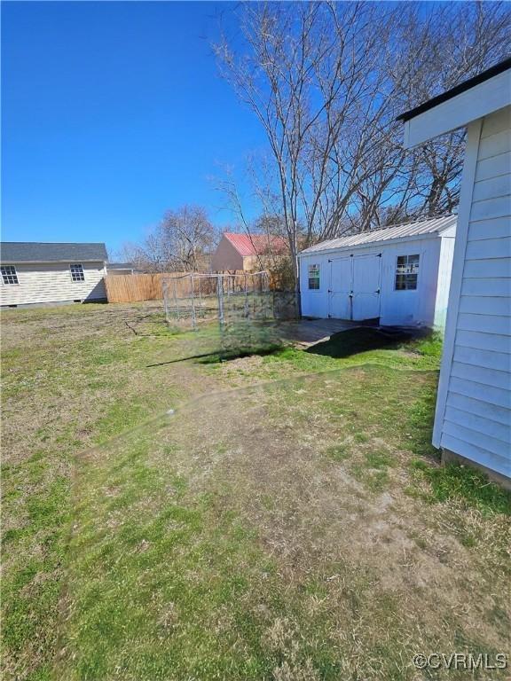 view of yard featuring an outbuilding and fence